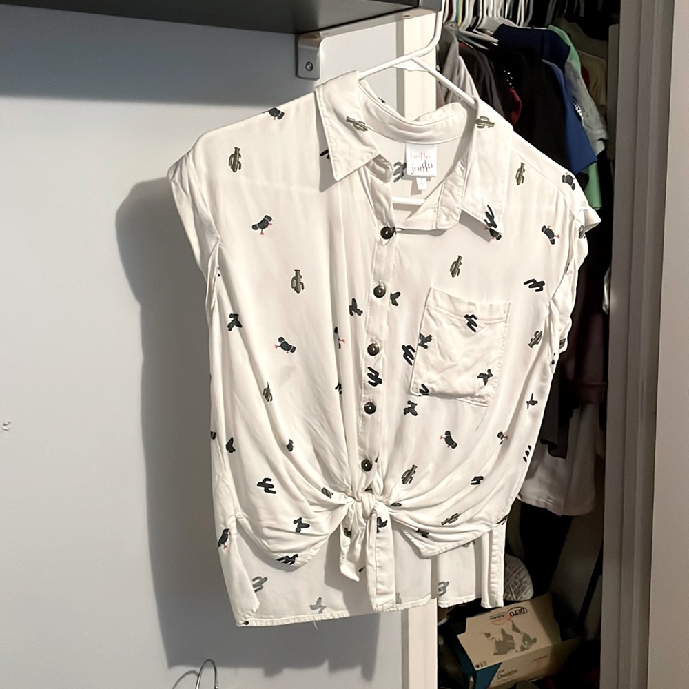 White shirt sleeve, button up top, with tie front.
